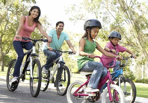 mom and dad with young daughter and son riding bicycles