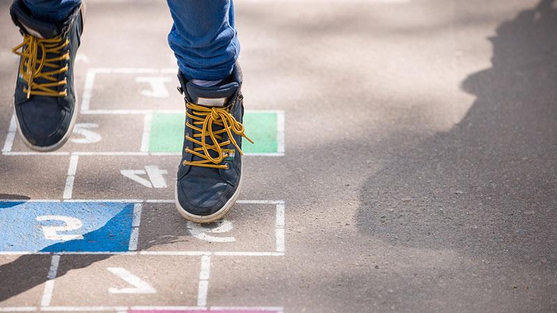 Close-up of a Child's feet playing hop scotch outdoors